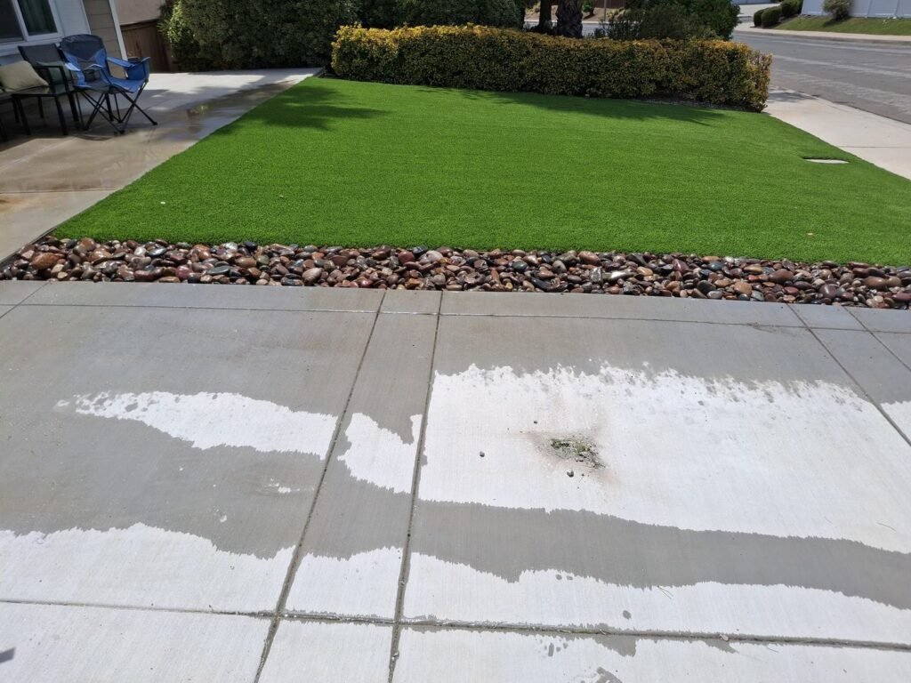 Finished front lawn artificial grass with a river rock border