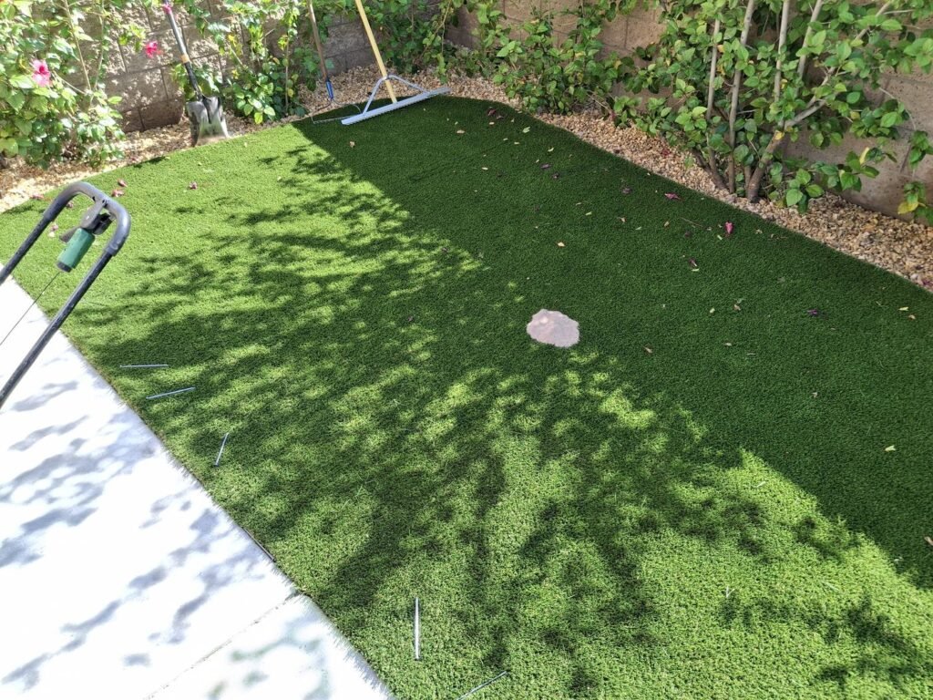Artificial grass strip along planting beds